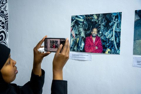 Visitor photographing a portrait at the AFAC photo exhibition