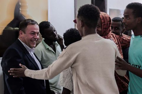 Guests greeting each other at the IOM photo exhibition