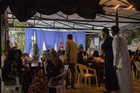 Creative meet-up in the courtyard with a speaker on the blue-curtain stage