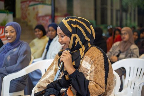 Woman in the audience asking a question with a microphone
