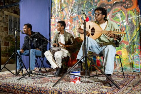 Oud player and two musicians performing at the open mic