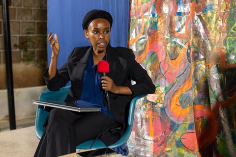 Guest speaking in front of a colourful painted backdrop