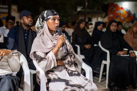 Woman in the audience speaking into a microphone