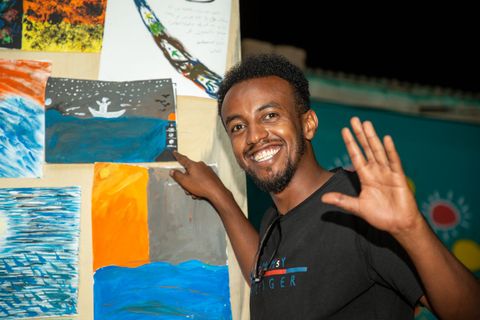 Participant with paintings from the art therapy workshop