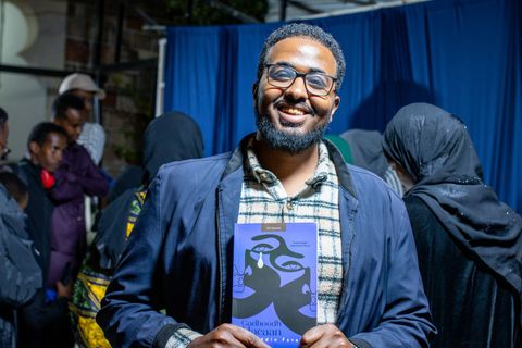 Guest smiling and holding his book